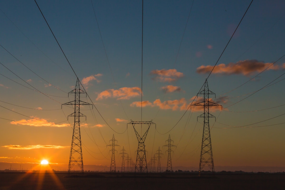 High-voltage transmission towers and power lines at sunset