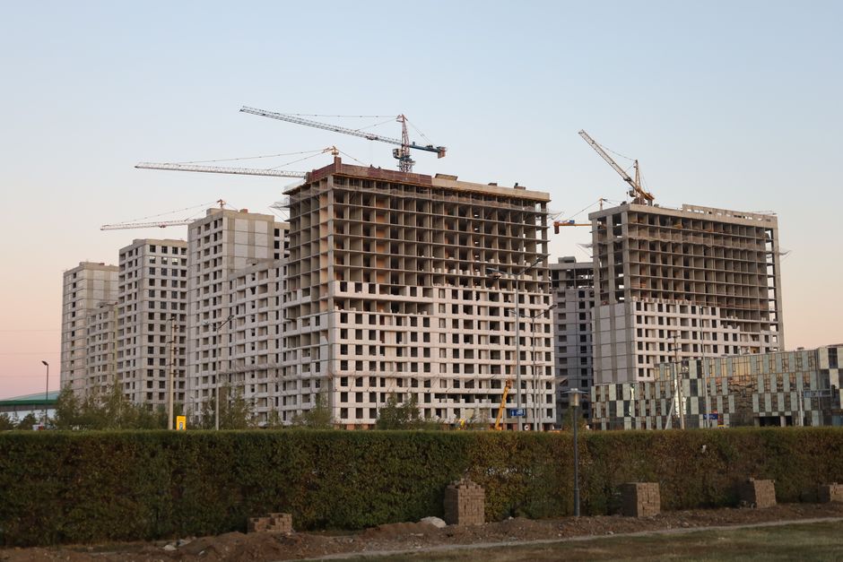 GS E&C stock context image of residential towers under construction at dusk