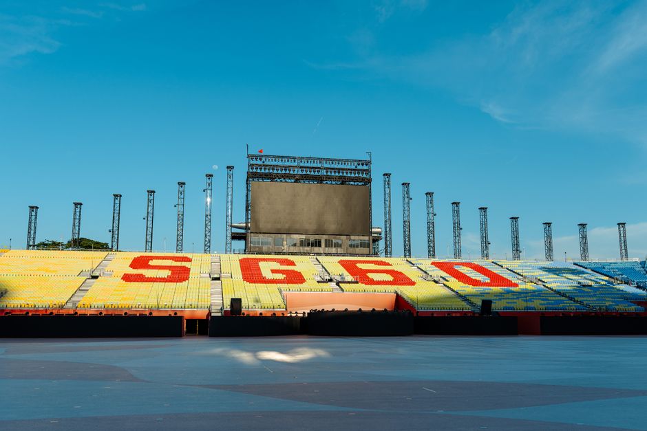 A large open-air concert stage with lighting rig and stadium seating (stock image)