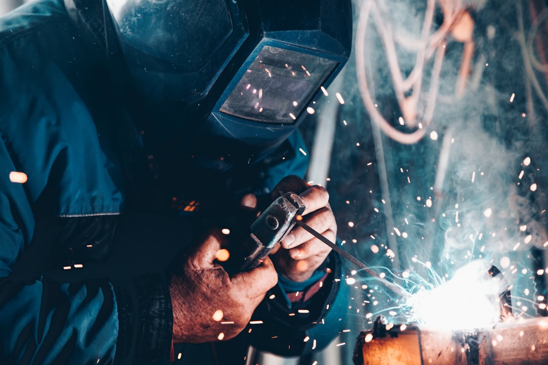 Welder joining steel components in a fabrication shop