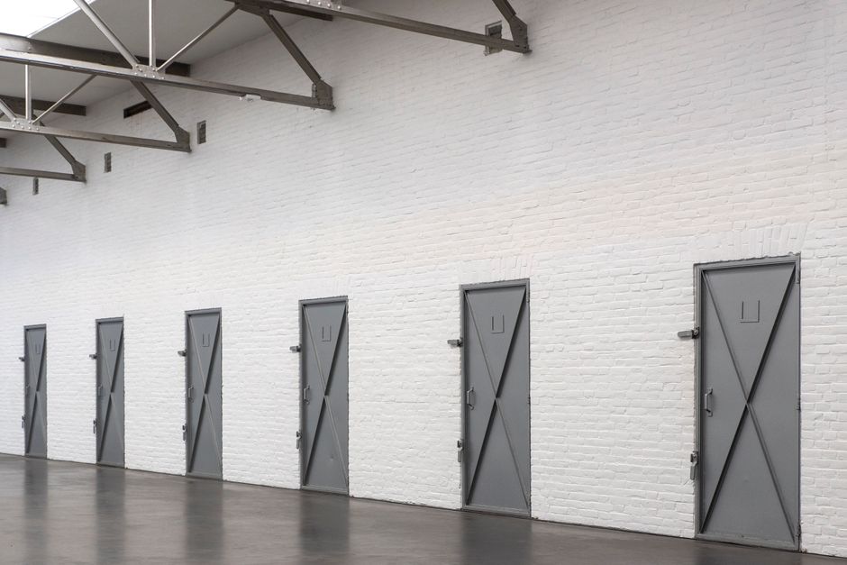 A row of steel doors along the wall of an industrial hall
