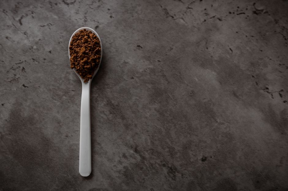 Instant coffee granules on a spoon, illustrating the Dongsuh net margin analysis