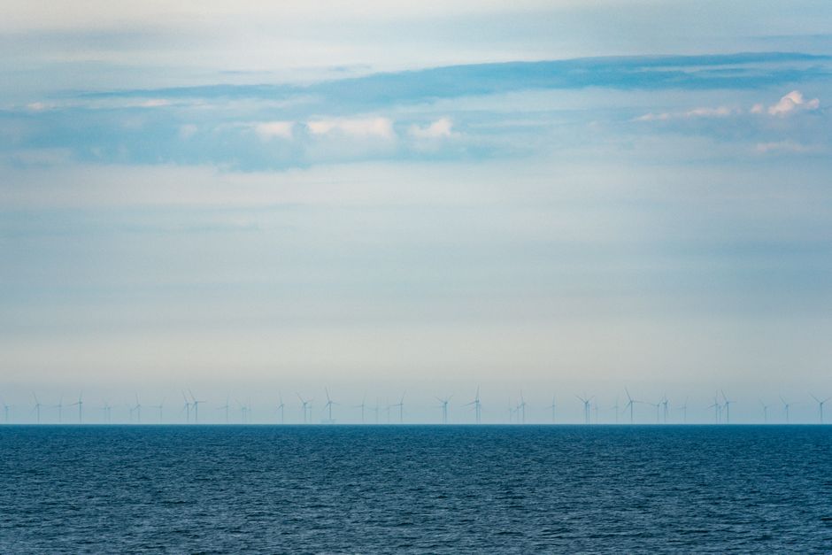 Offshore wind turbines standing at sea under a cloudy sky
