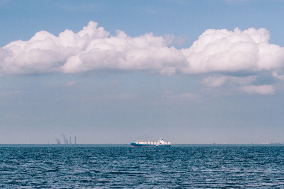A merchant vessel on open water under a cloudy sky