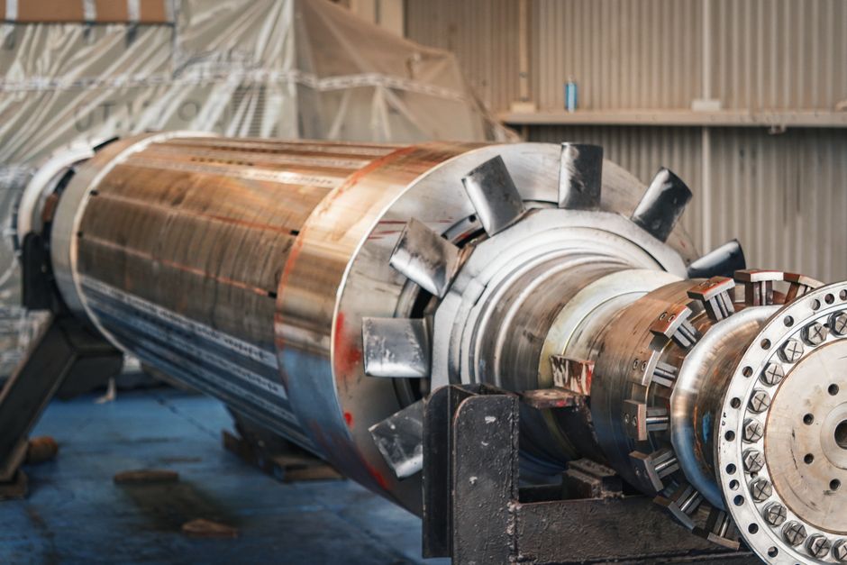 A large machined shaft assembly on a factory floor