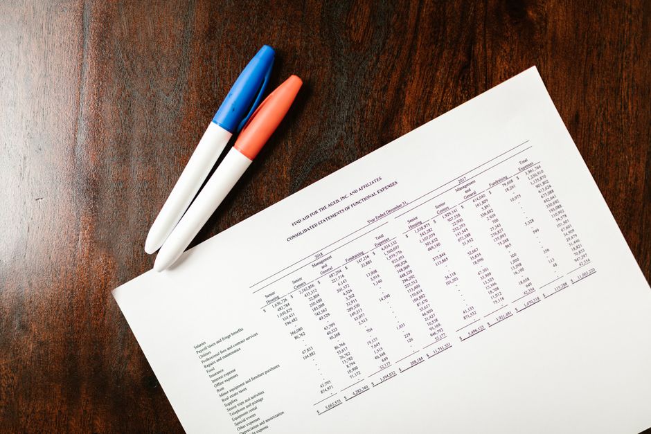 A printed financial statement and two pens on a desk