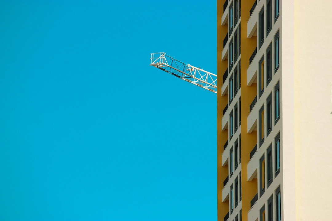 A residential tower under construction beside a crane jib