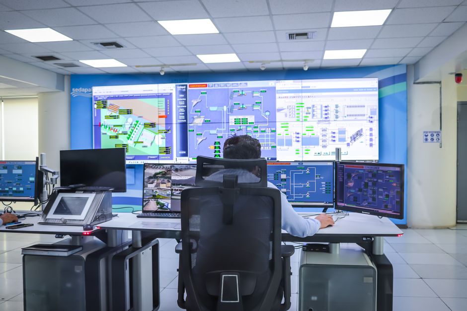 Control room screens of the kind behind POSCO DX stock and its factory automation work