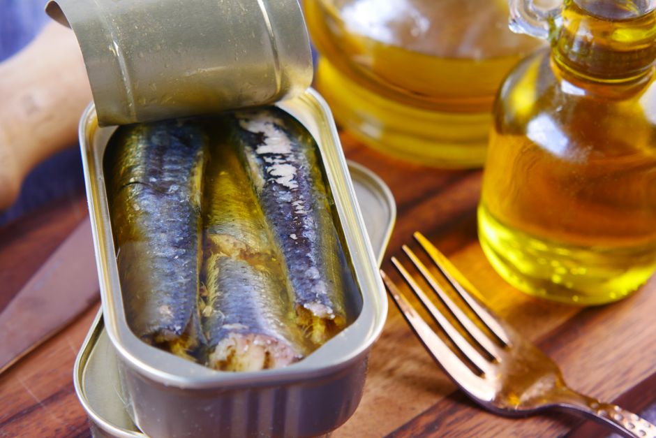 An opened tin of canned sardines beside olive oil, illustrating Sajo Daerim stock coverage