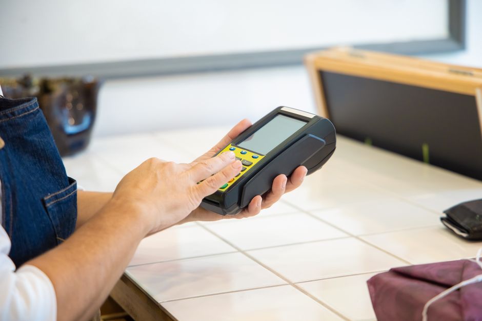 A payment terminal handled at a store counter, the business behind Samsung Card stock