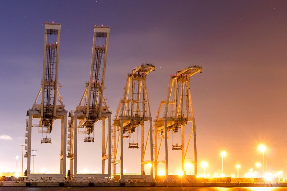 Ship-to-shore container cranes standing on a quay at dusk