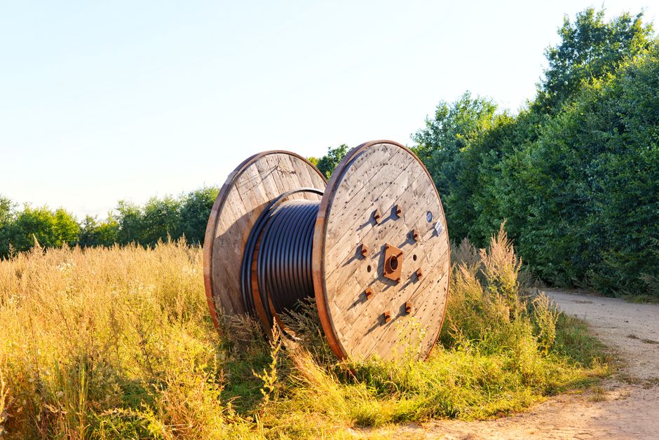 A large wooden cable drum standing outdoors